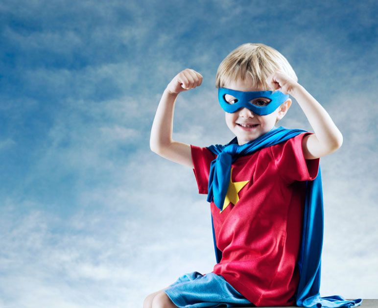 Boy flexing in superhero outfit