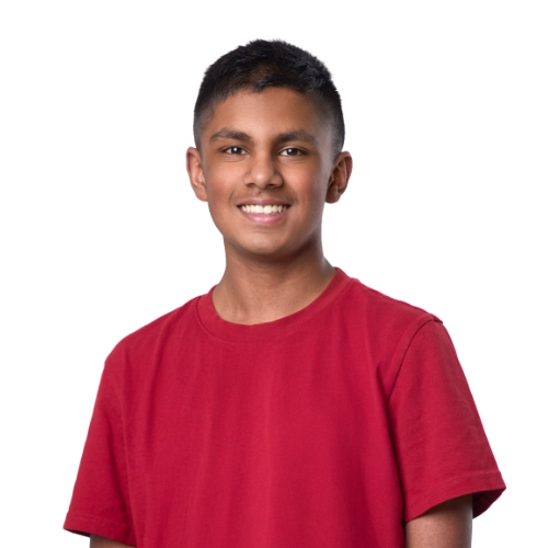 Portrait of Uday, a 14-year-old boy in a red shirt smiling against a light background