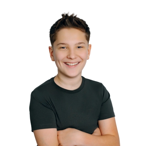Portrait of Loukian, a 13-year-old smiling in a dark shirt against a light background
