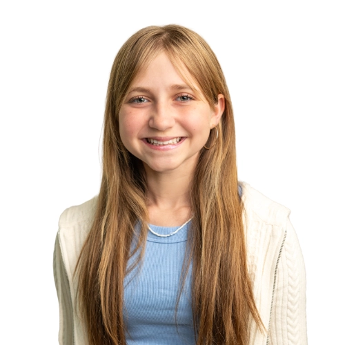 Portrait of Kate, a 14-year-old smiling in a blue top and light jacket against a light background